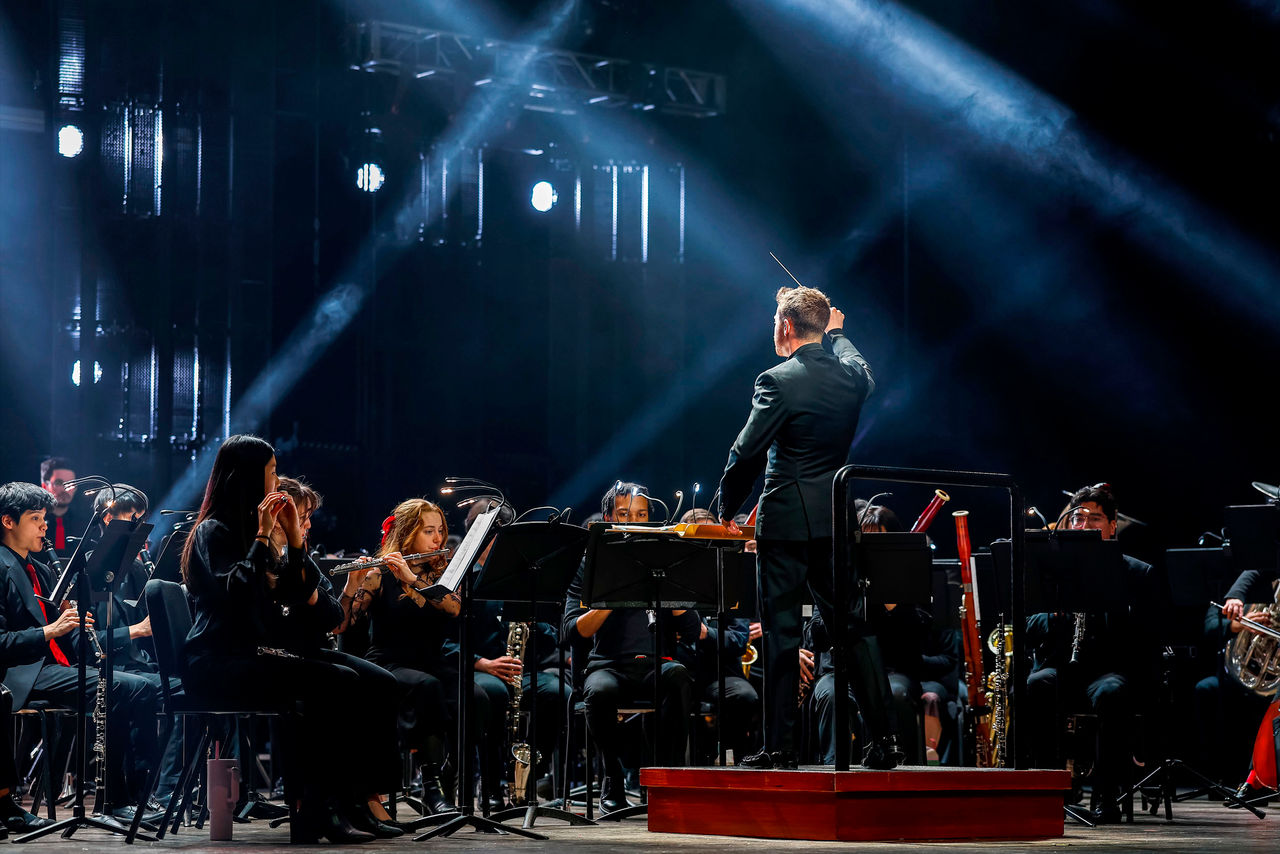 CCM Wind Symphony performs under dramatic blue lighting during the 2026 Moveable Feast event.