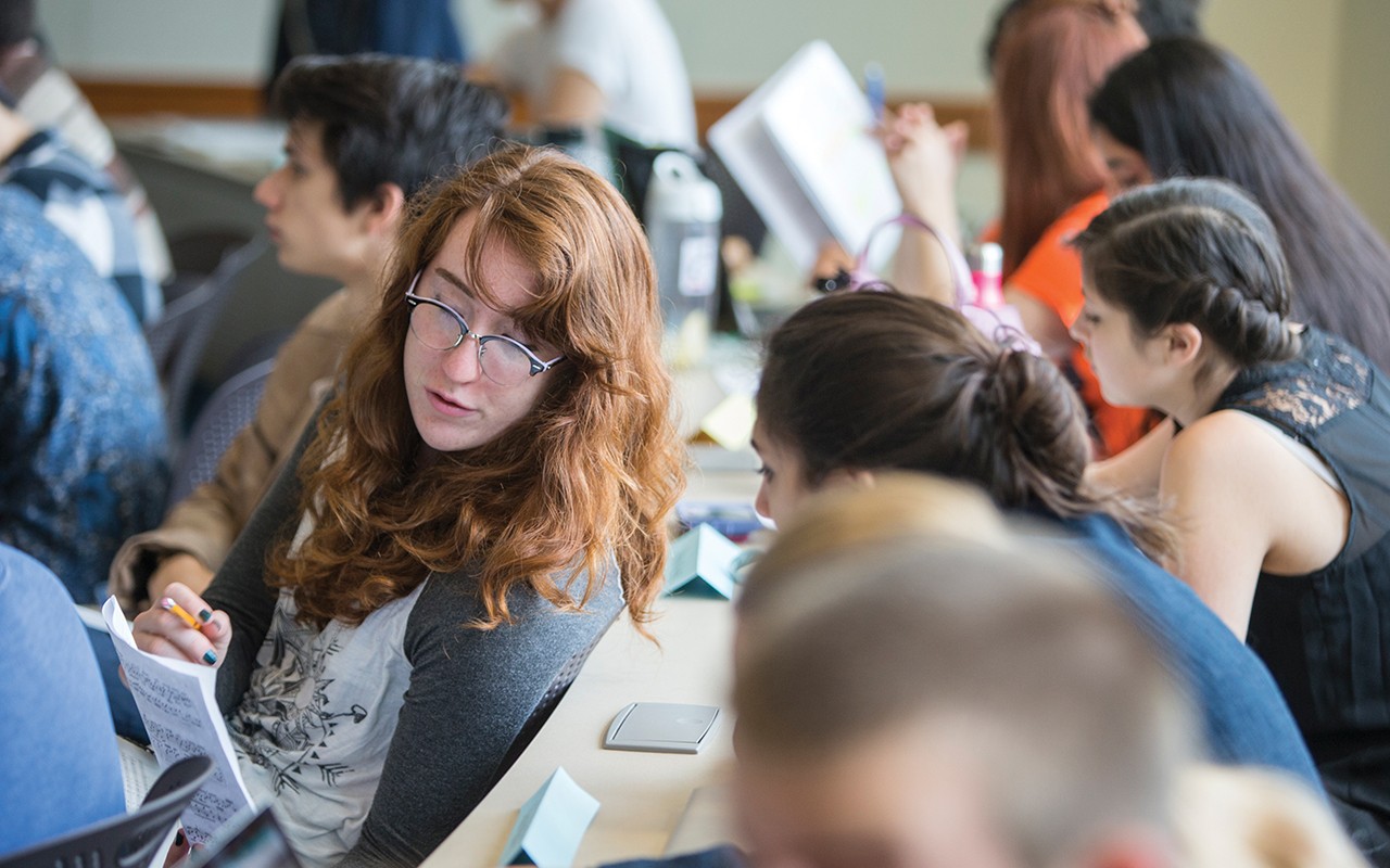 Female students discuss a piece of sheet music in a CCM Compostion classroom