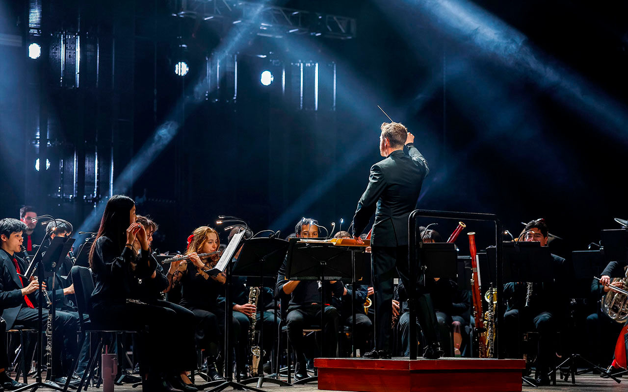 CCM Wind Symphony performs under dramatic blue lighting during the 2026 Moveable Feast event.