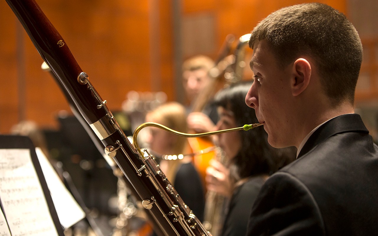 Male bassoon student performs with the wind ensemble in Corbett Auditorium