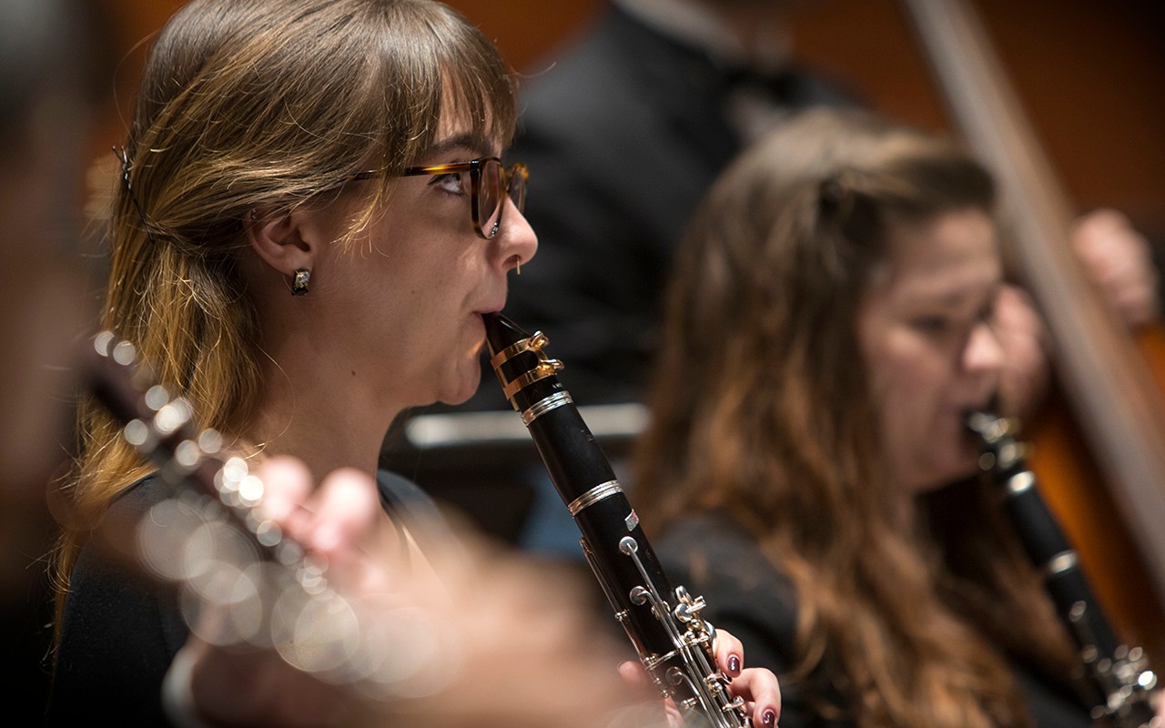 Female clarinet student performs with the wind ensembles  on the Corbett Auditorium stage
