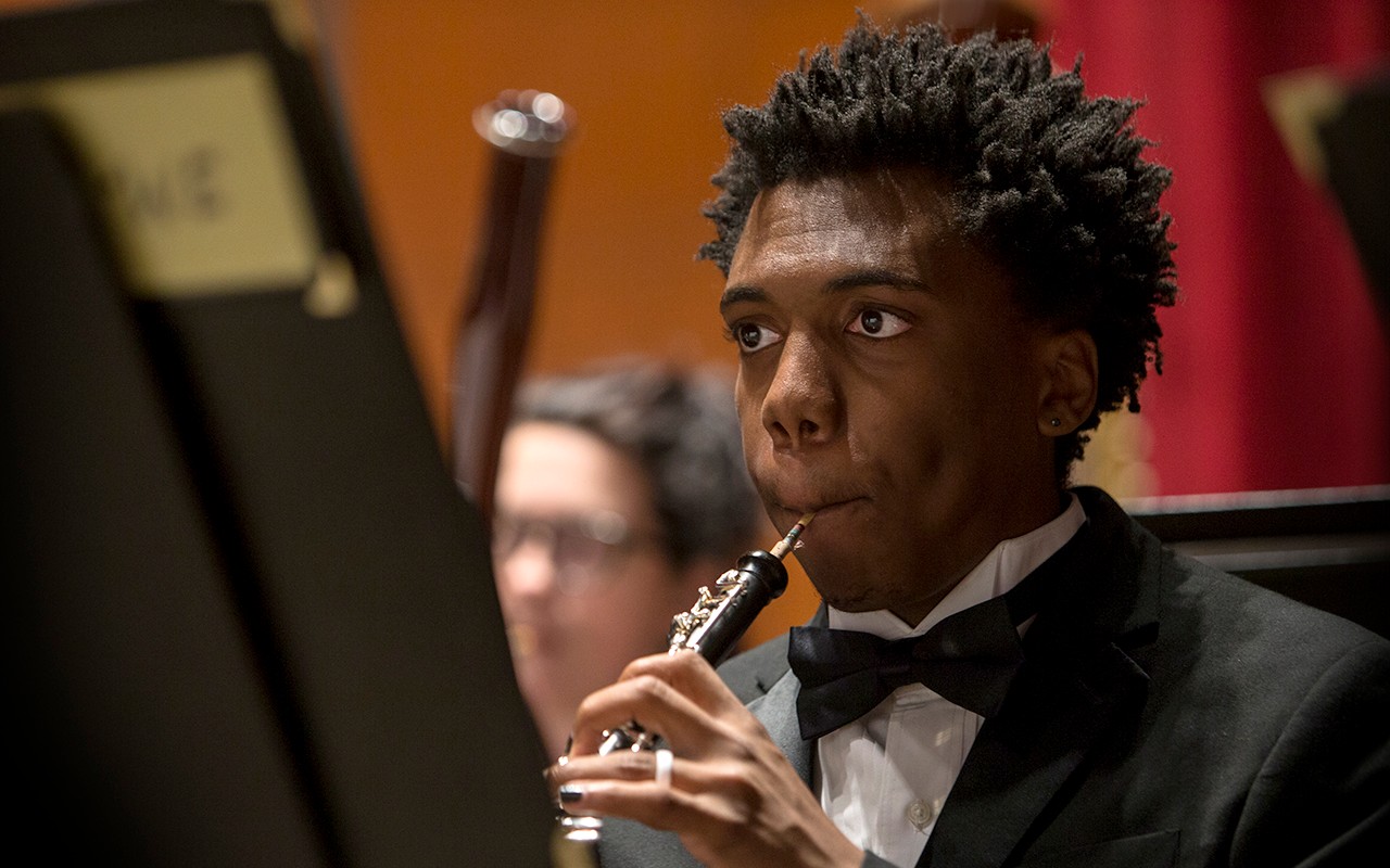Male oboe student performs with the concert orchestra in Corbett Auditorium
