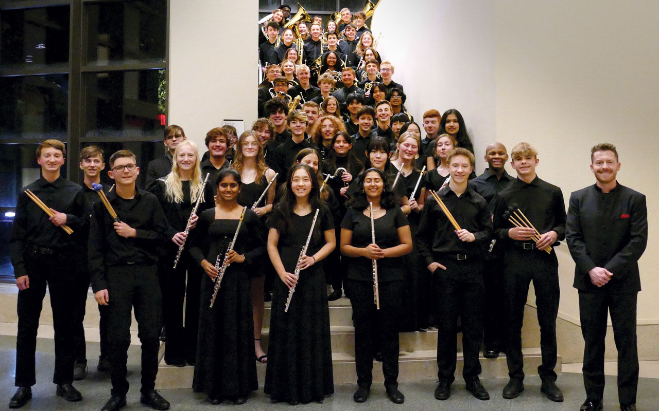 Memebers of the Cincinnati Youth Wind Ensemble (CYWE) pose on a staircase with their instruments