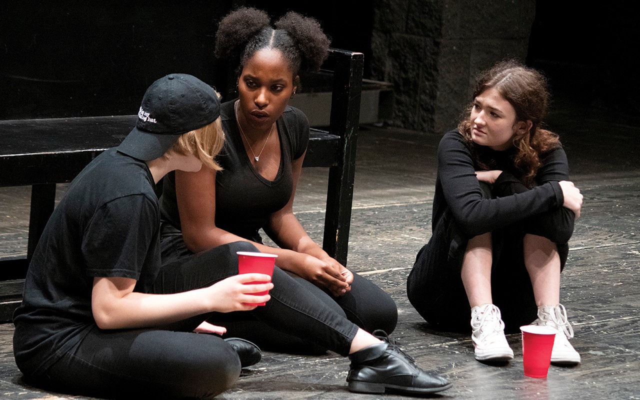 Three high school aged students sit in rehearsal during a Theatre Arts acting class